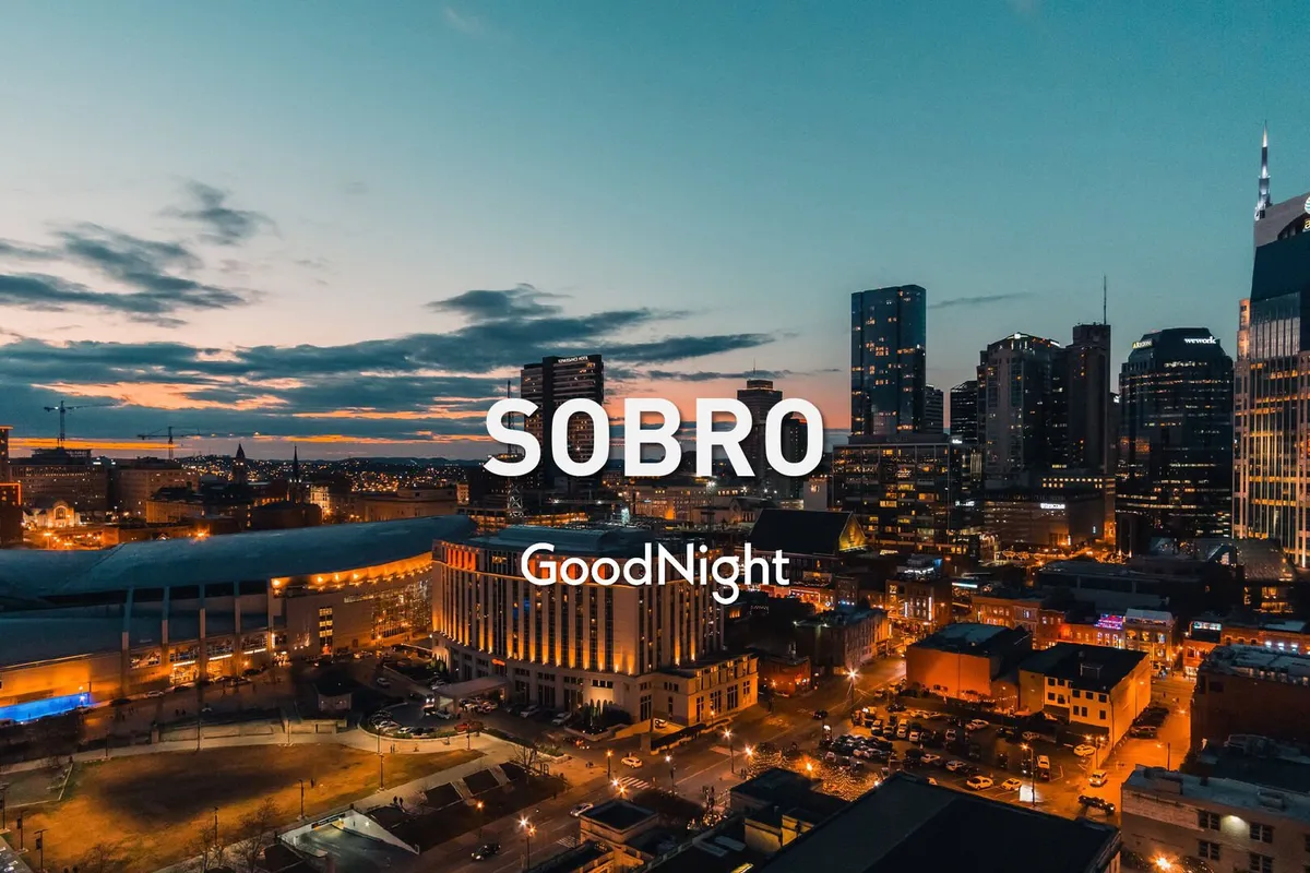 A panoramic view of the Nashville city skyline at sunset with streets illuminated by lights. The image highlights the city’s dynamic atmosphere and the blend of urban excitement with scenic beauty as evening falls.