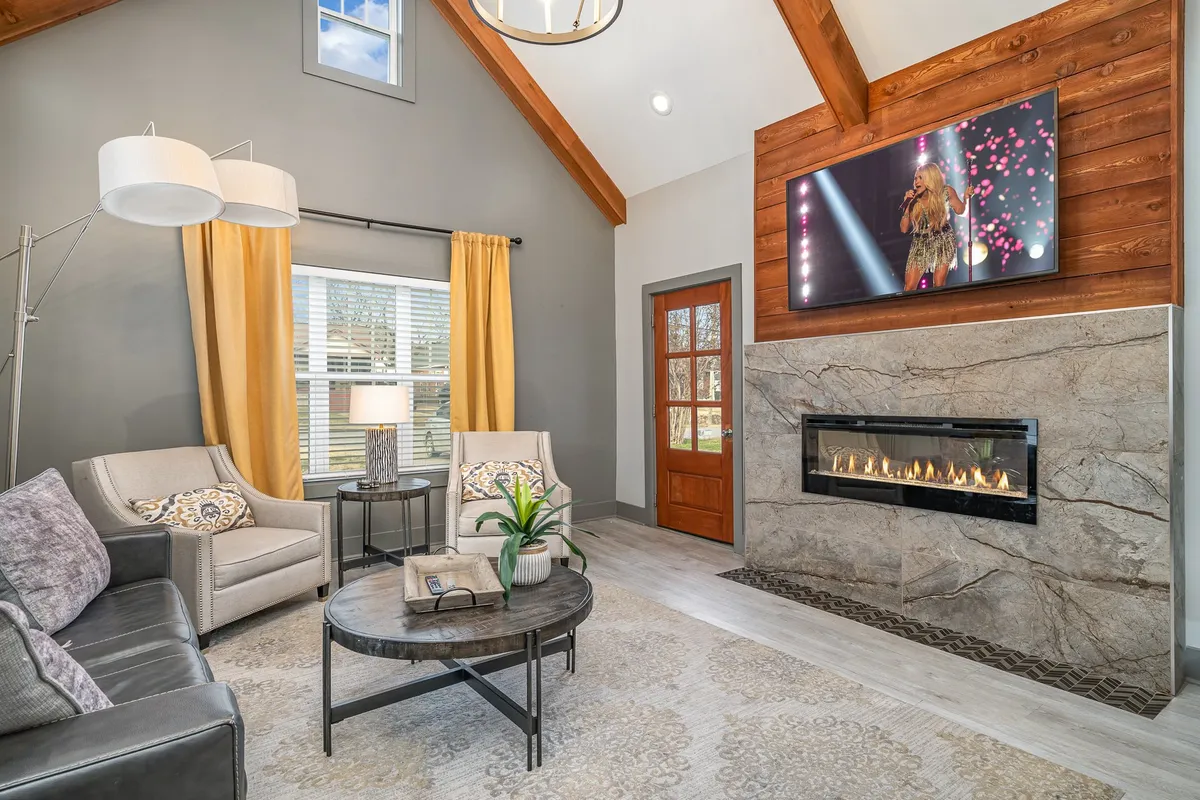 This inviting living room features a cozy fireplace, a large window allowing natural light, a TV, and a comfortable seating arrangement. The space feels both private and homely—ideal for relaxing, entertaining, or unwinding after a day out.