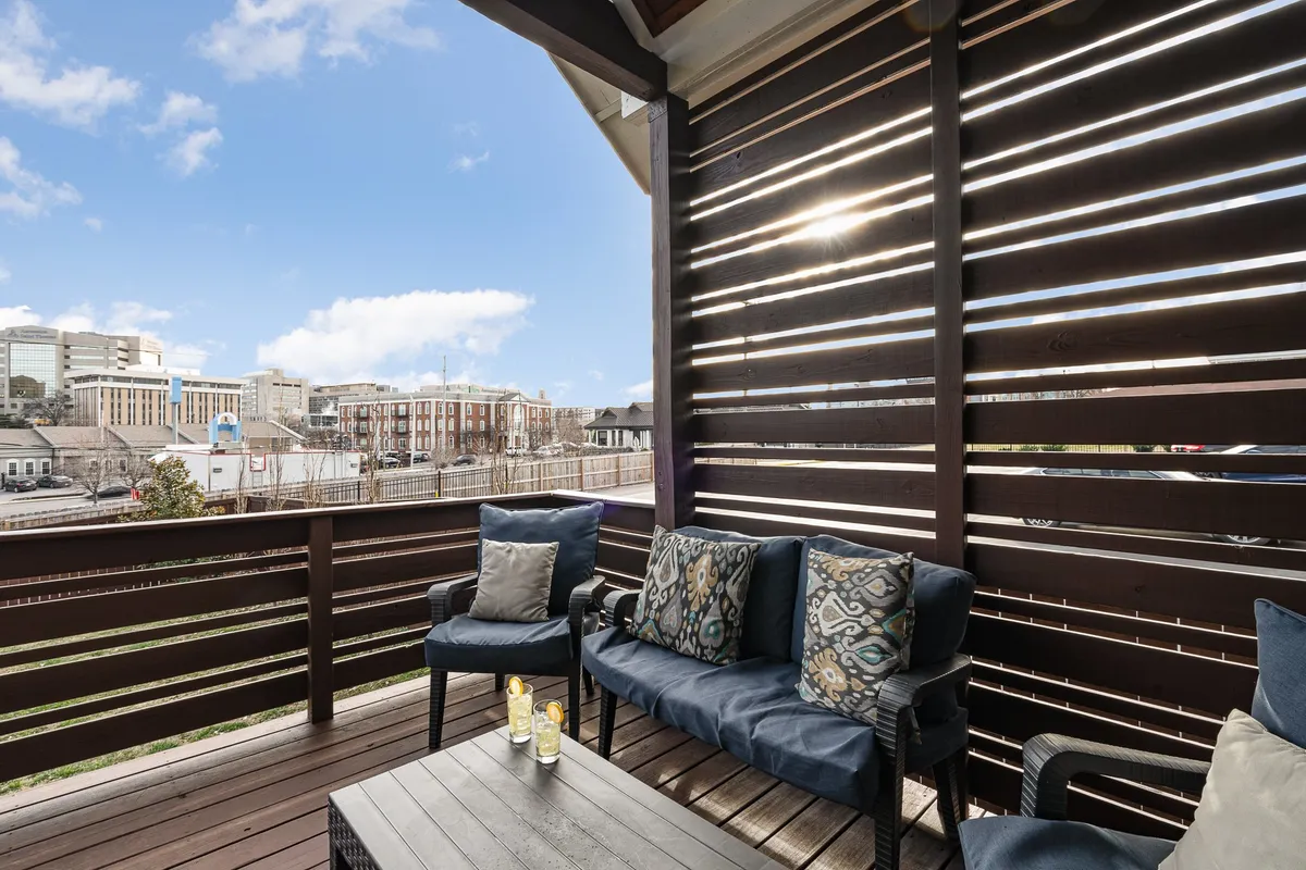 An exterior seating area with decorative pillows set against a view that opens up to the skyline, creating an inviting spot to enjoy morning coffee or evening relaxation. The comfortable, welcoming setup is ideal for both solo moments and shared experiences.