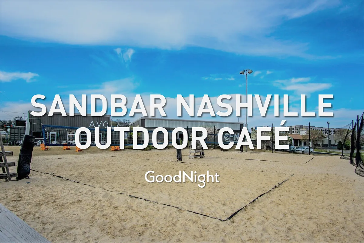 An exterior view of an outdoor café area featuring a sand volleyball court, casual seating, and the glow of sunset. The scene is lively and relaxed, highlighting social opportunities and the outdoor dining culture characteristic of Nashville’s culinary scene.
