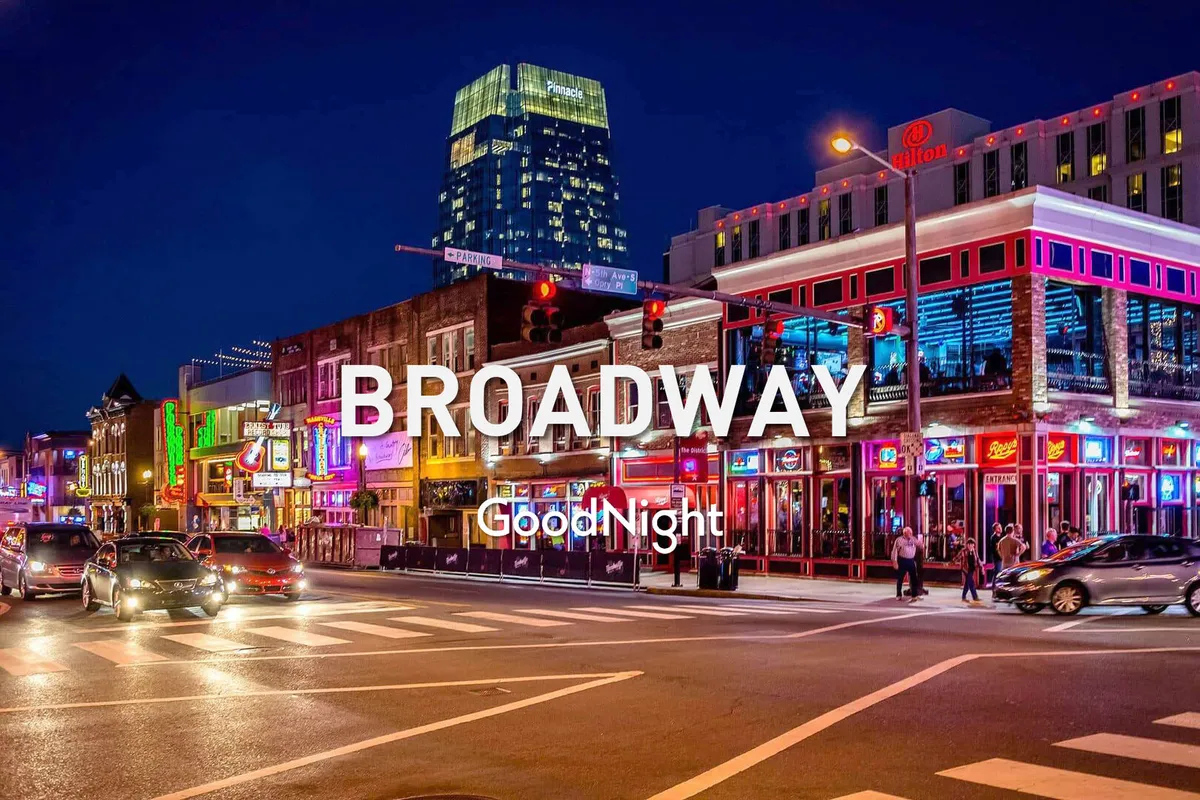 A lively nighttime street scene with neon signs, bustling crowds, and high-rise buildings. The vibrant lights and people walking convey the energy and excitement of Nashville’s nightlife and entertainment district.